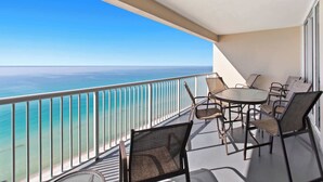 Een balkon met uitzicht op de oceaan, voorzien van een tafel en stoelen.