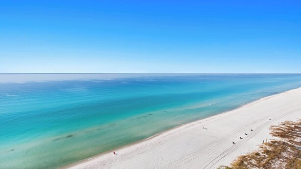Een strand met helder turquoise water en een zandstrand.