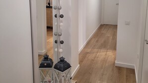 Un pasillo con un espejo, luces decorativas y dos faroles.