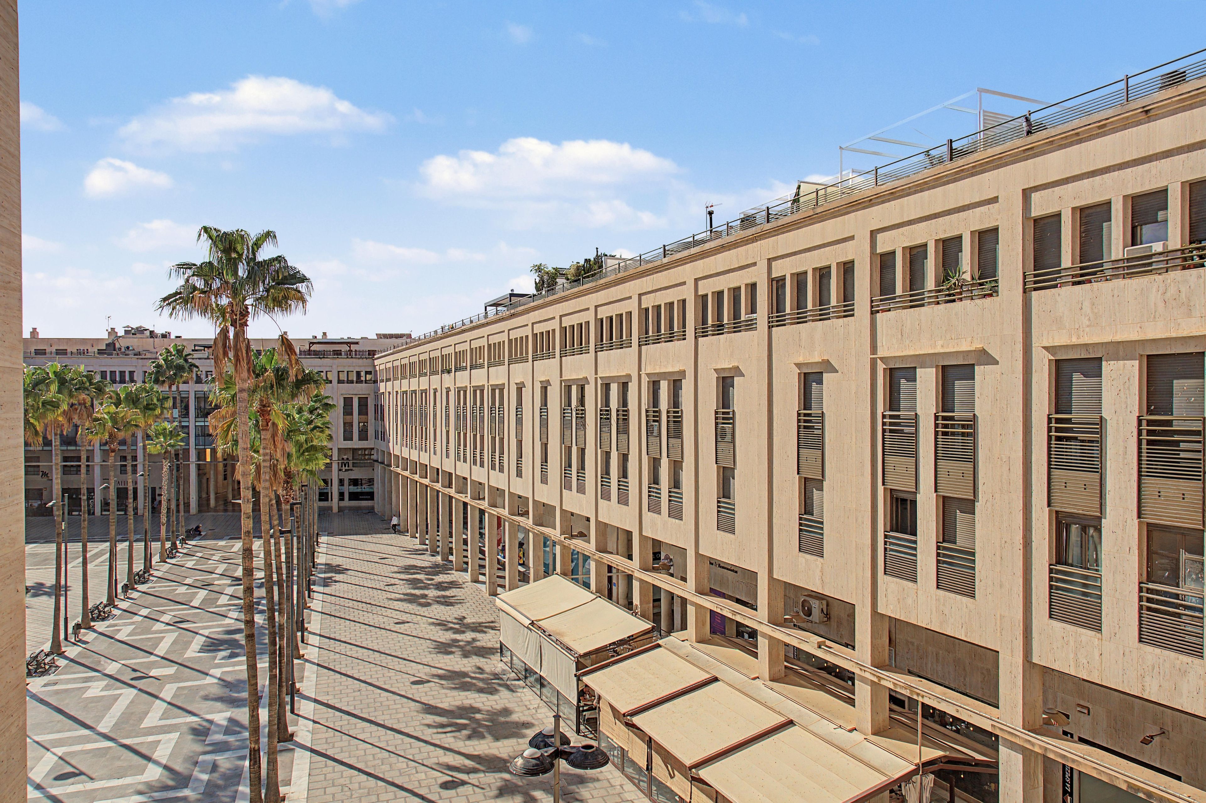 Un edificio moderno con varias terrazas y un pavimento con diseño.