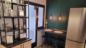 Una cocina moderna con refrigerador empotrado, armarios de madera, encimera negra y una pared de acento verde.