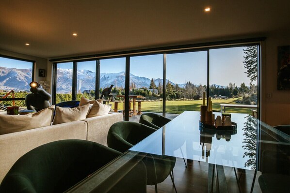 Enjoy meals at the large dining table surrounded by comfortable chairs, with a view of the surrounding mountains and golf course.