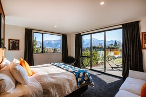 Enjoy breathtaking mountain views from the comfort of your room, featuring a large bed and a sofa.
