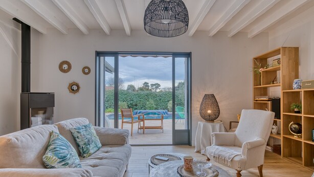 A modern living room with a sofa, armchair, coffee table, and a bookshelf. - 4-Star Villa Arcachon – Heated Pool, Garden & Petanque, Sleeps 8 (La Teste-de-Buch)