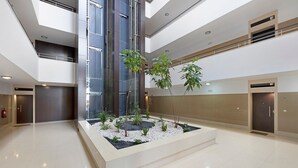 Un espace intérieur moderne doté d’un jardinier central, de plusieurs étages et d’un extincteur.