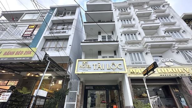 Un hôtel doté d’une enseigne bien visible, de nombreux balcons et d’une façade moderne.