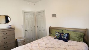 A bedroom with a bed, dresser, and a ceiling fan. - Cozy American Style Cottage (Sioux City)