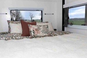 Relax in this serene bedroom with a large bed and scenic views.