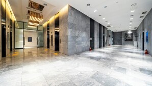 A spacious lobby with marble flooring, glass doors, and modern lighting fixtures. - GLOUCESTER HOTEL CHEONGJU (Cheongju)