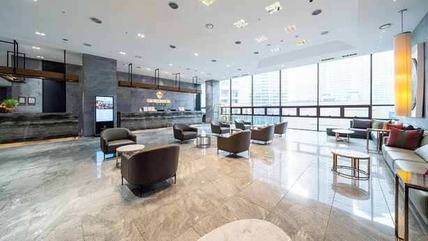 A spacious lobby with a reception desk, seating area, and large windows offering a city view. - GLOUCESTER HOTEL CHEONGJU (Cheongju)