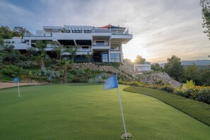 A modern house with a well-maintained lawn and a golf flag.