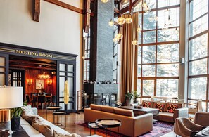Una amplia sala de reuniones con chimenea, ventanas grandes y mobiliario moderno.