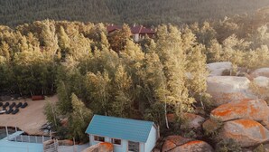 A cabin with a dock, surrounded by trees and rocks, near a body of water. - Dom u ozera  (Burabay)