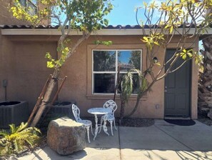 Welcome to a serene home with an entrance, outdoor seating area, and beautiful natural surroundings.