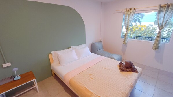 A neatly arranged bedroom with a bed, bedside table, and a window with curtains.
