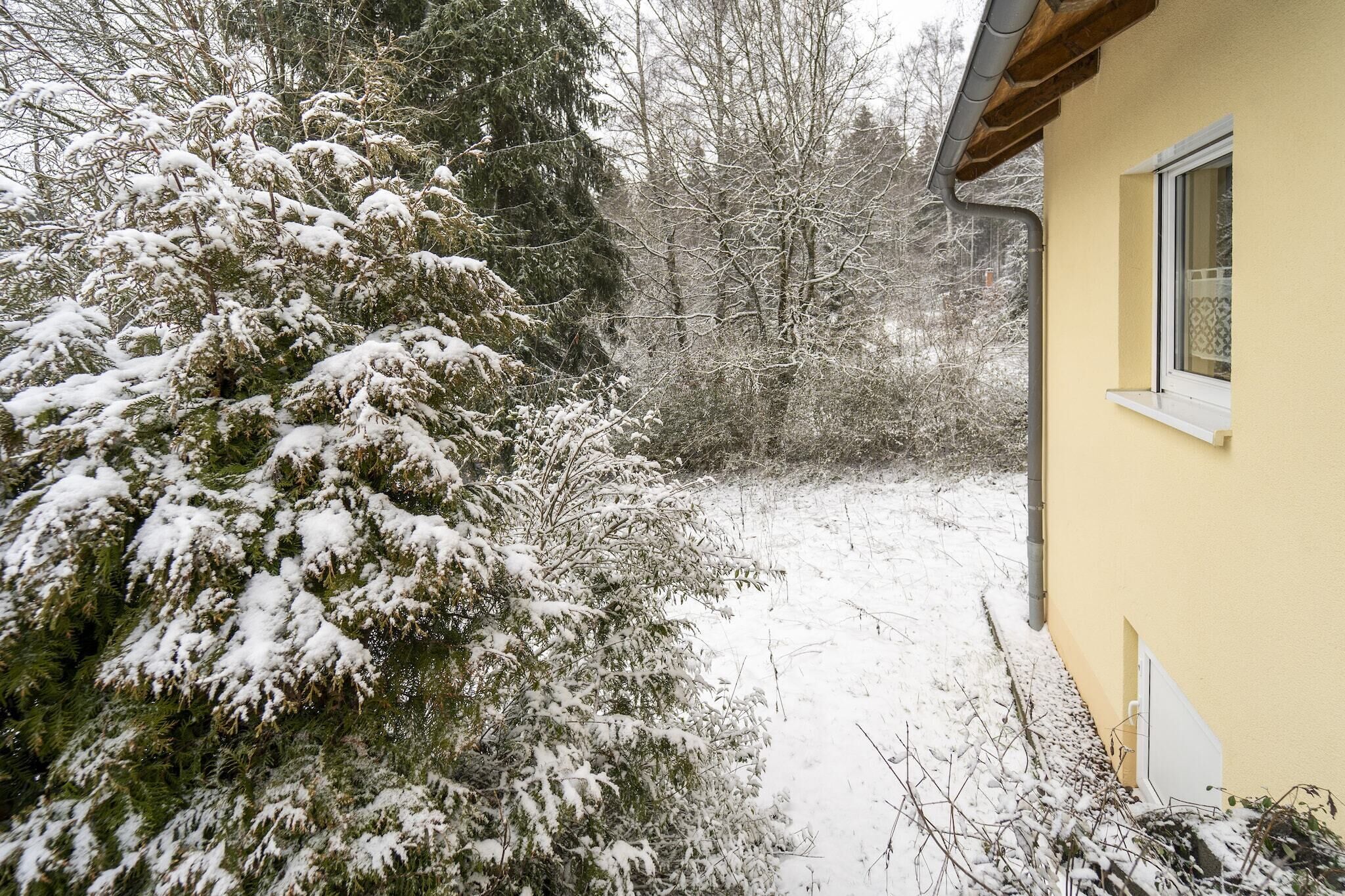A snow-covered landscape with a yellow building and a window.