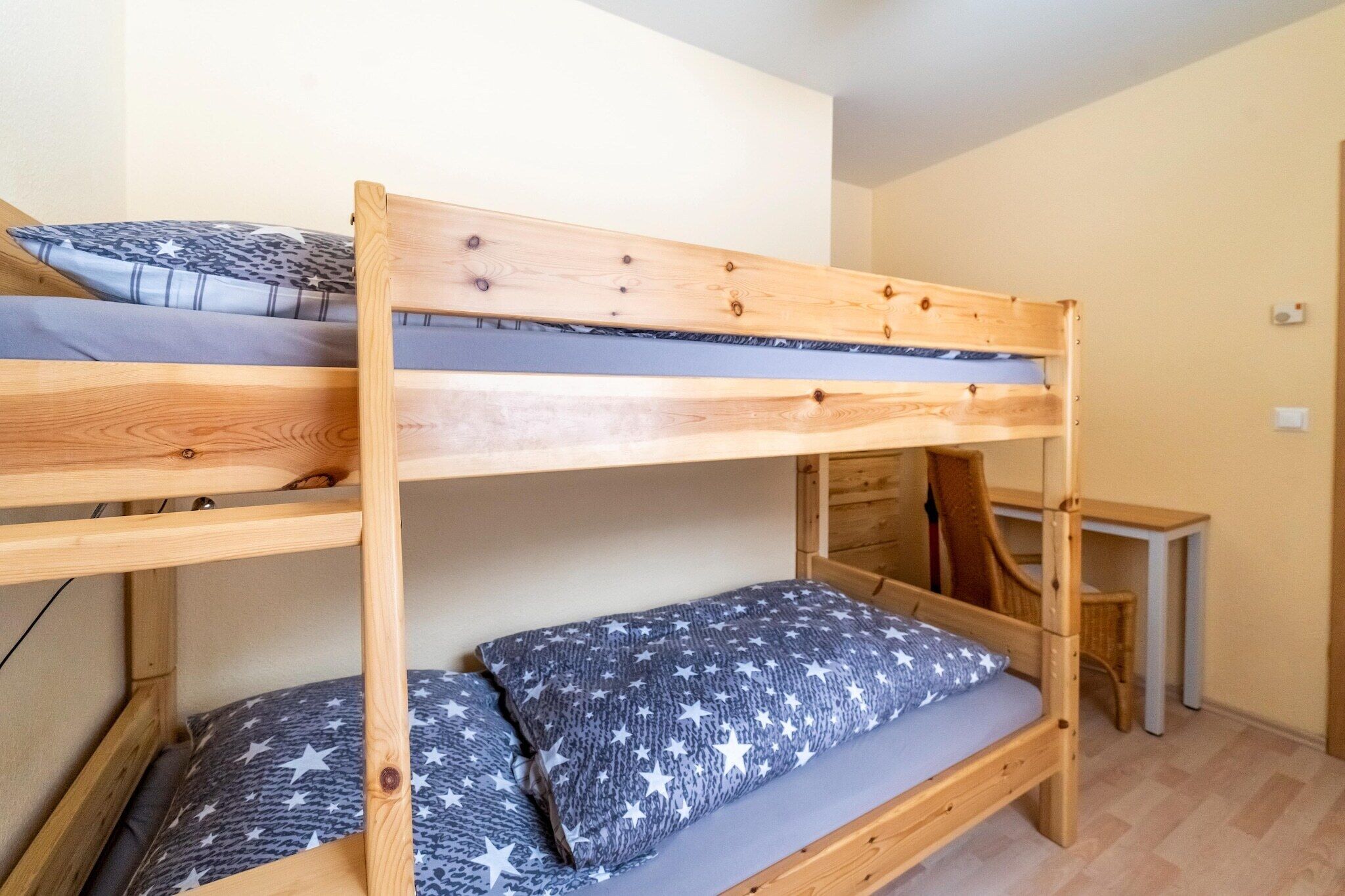 A bunk bed with a desk and chair in a small room.