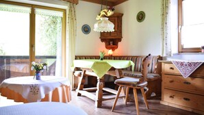 Un coin repas en bois avec une table, des chaises et un banc.