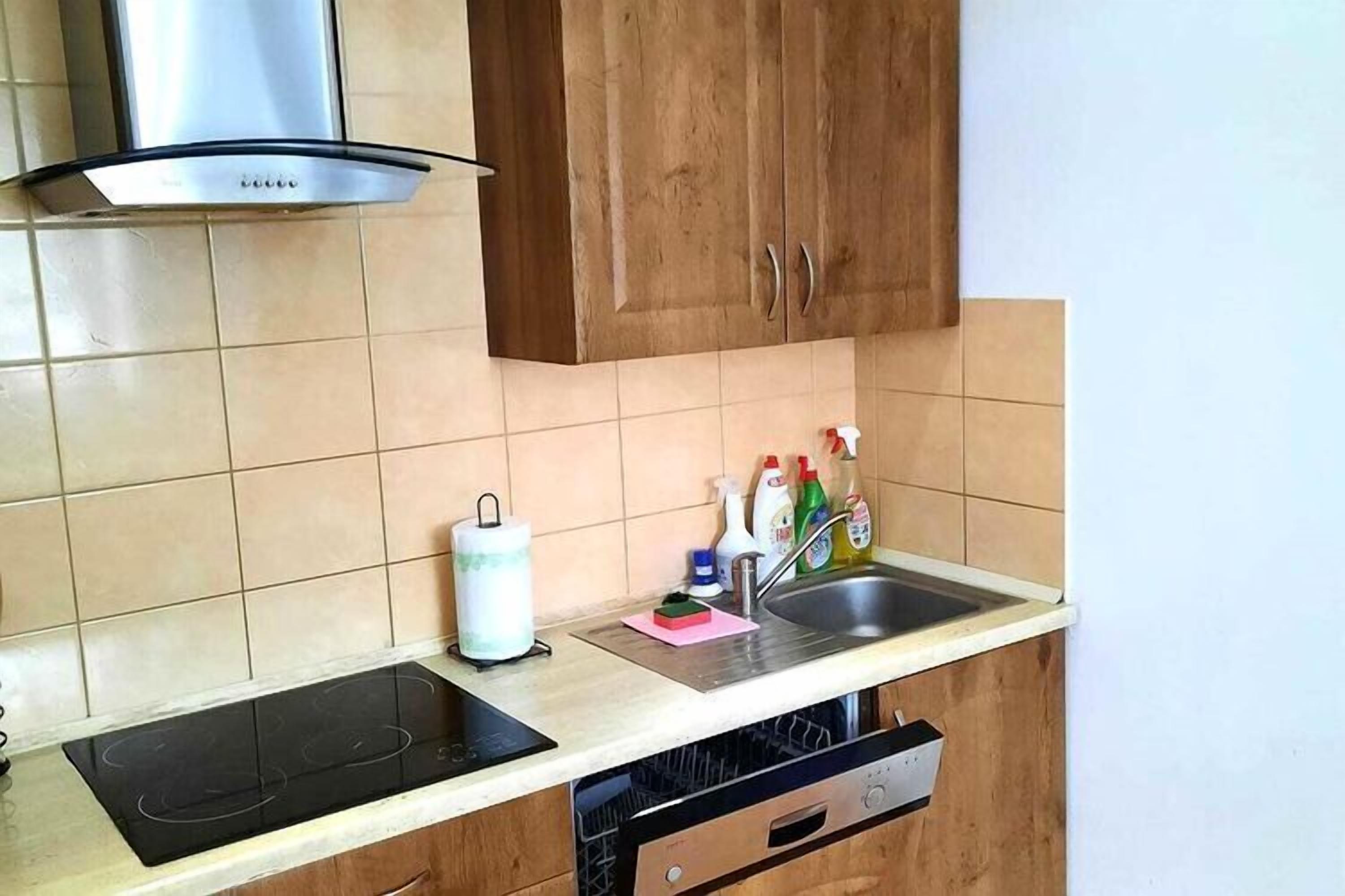 Eine Küche mit Herd, Spüle und Holzschränken.