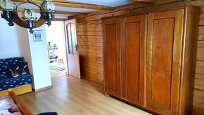 A room with wooden paneling, a large wardrobe, a sofa with patterned cushions, and a chandelier. - Spacious holiday home in Piechowice with garden (Piechowice)