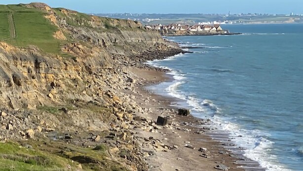 A coastal landscape with rocky cliffs, a sandy beach, and a distant village. - Cosy cottage a stone's throw from Cap Gris Nez (Audinghen)