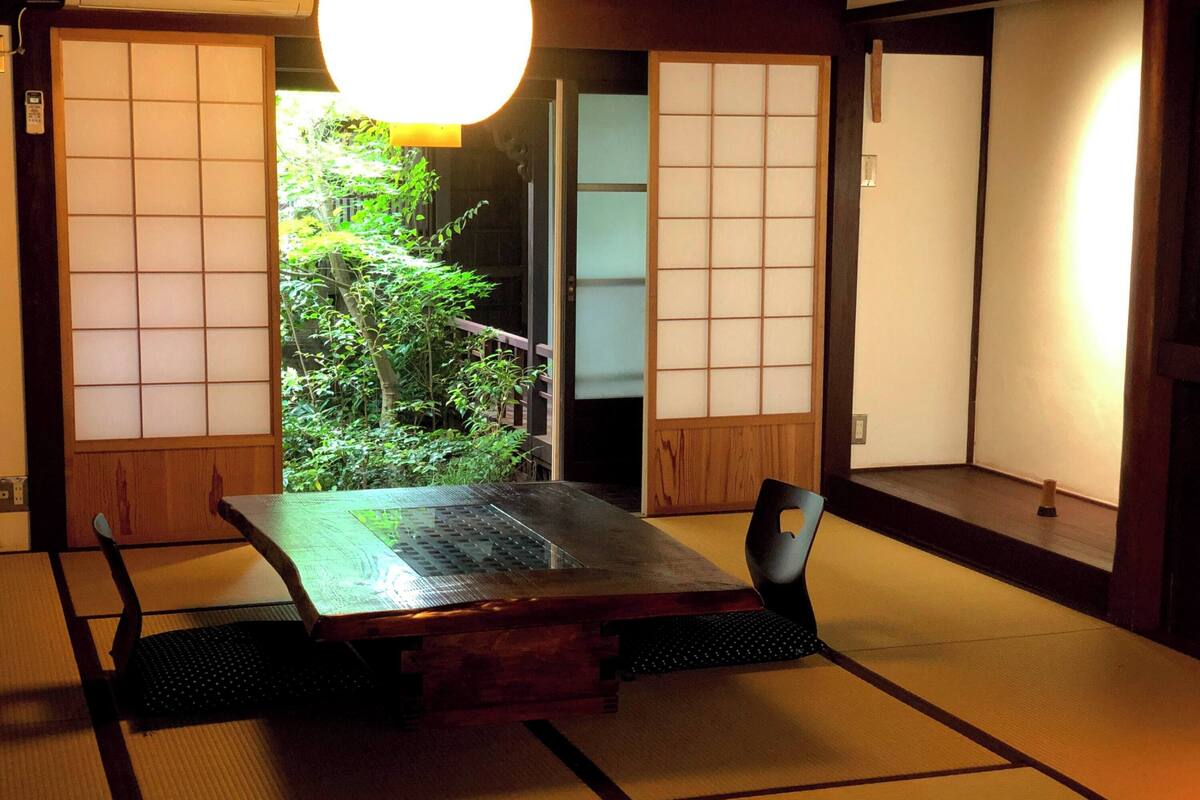Ein traditioneller japanischer Raum mit Tatami-Böden, einem niedrigen Tisch und Schiebetüren.