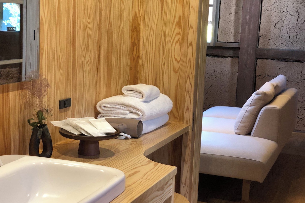 Un bagno con un mobiletto in legno, un lavandino e un porta asciugamani.