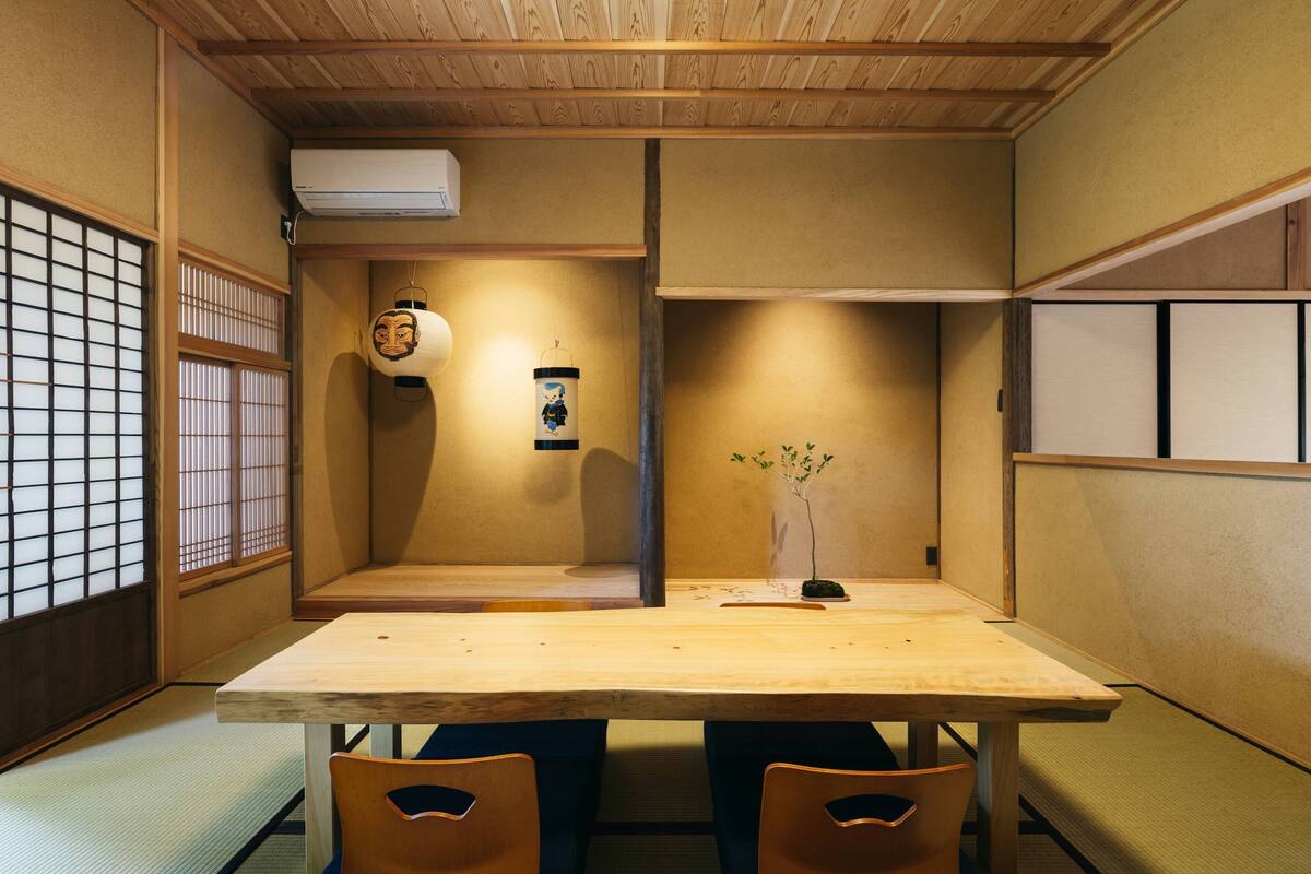 Ein traditioneller japanischer Raum mit Tatami-Böden, einem niedrigen Tisch und einem Shoji-Bildschirm.