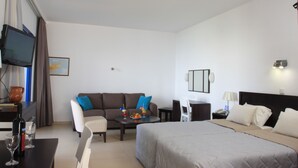 Una camera d'albergo con un letto, un divano, un tavolo da pranzo e una TV.