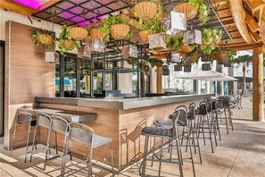 Enjoy a refreshing drink at the outdoor bar, surrounded by lush greenery and a stylish counter.