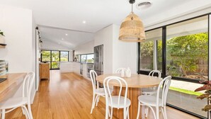 Una cocina moderna con comedor, ventanas amplias y vistas al exterior.