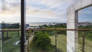 Un edificio moderno con amplios ventanales que ofrecen vistas al mar y la vegetación circundante.