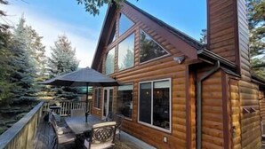 Una baita di legno con veranda, un tavolo e sedie.