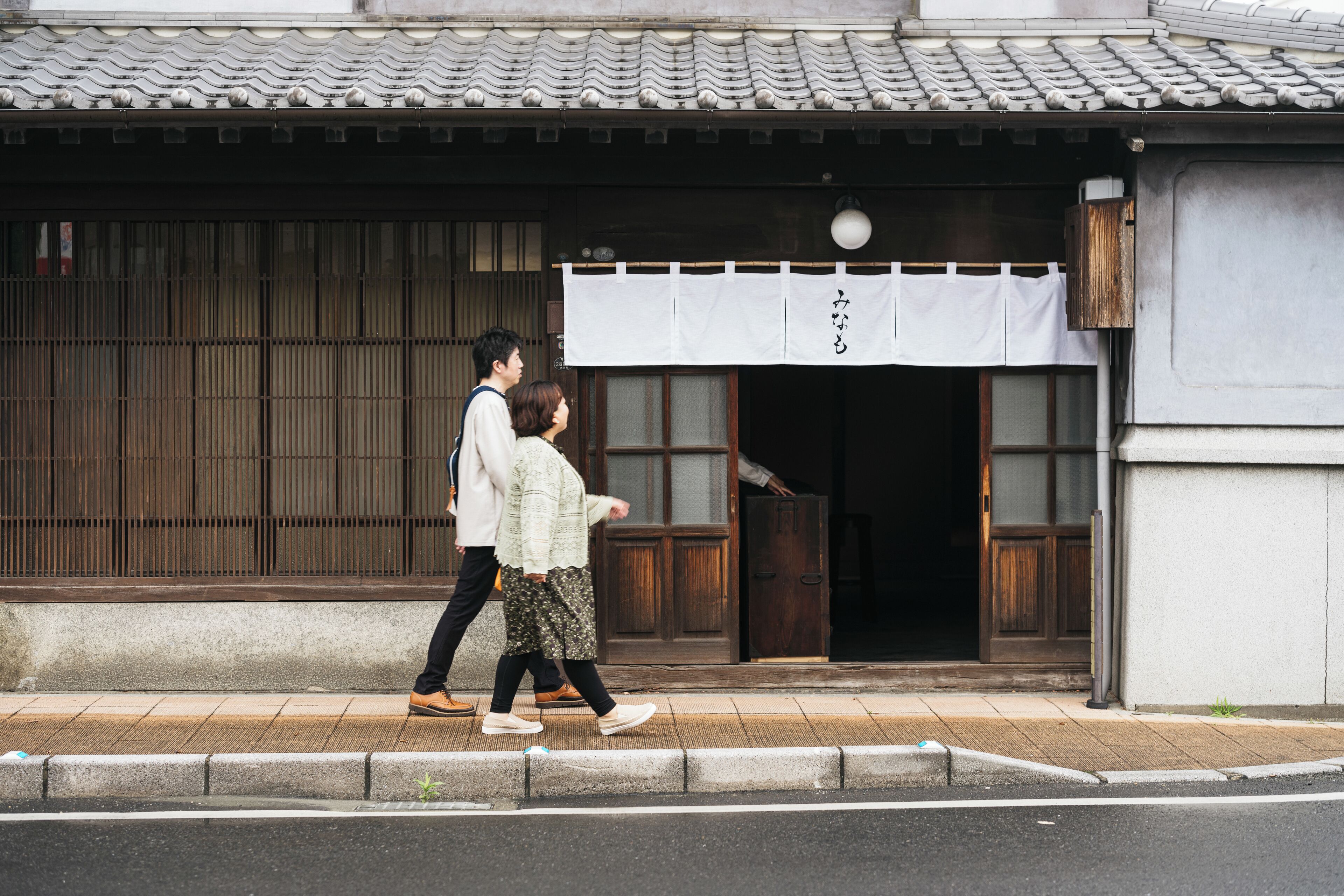 A traditional Japanese building with a tiled roof and wooden doors.
