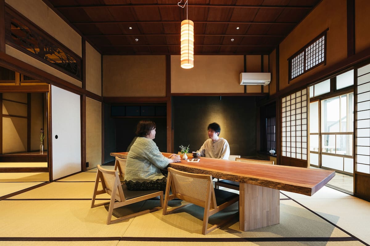 A traditional Japanese room with tatami flooring, a low wooden table, and shoji screens.