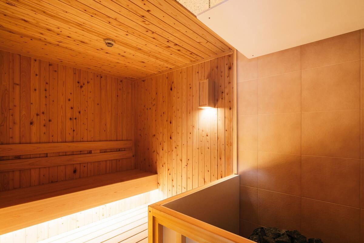 A sauna room with wooden walls and a tiled floor.