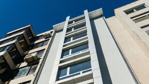 A modern building with a prominent central staircase, large windows, and a clear blue sky. - Select Porto Suites (Porto)