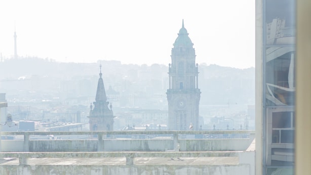 A view from a window with a cityscape in the background, including a prominent clock tower. - Select Porto Suites (Porto)