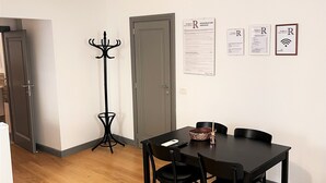 A dining area with a table and chairs, a coat rack, and a wall-mounted air conditioner. - APARTMENT 4 PANTHEON (Roma)
