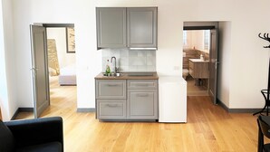 A modern kitchen with grey cabinets, a white refrigerator, and a wooden countertop. - APARTMENT 4 PANTHEON (Roma)