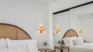 Ein Hotelzimmer mit einem großen Bett, zwei Nachttischen und einem Spiegel.