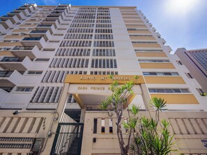 Ein Hochhaus mit einem Schild, auf dem 'KUHIO AT MAIKIKI' und '2464 PRINCE' steht.