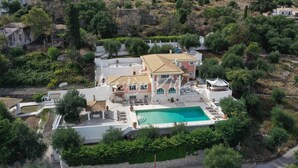 An aerial view of a large villa with a swimming pool, surrounded by lush greenery and other buildings. - Villa with enormous Pool in Kassiopi (Kassiopi)