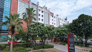 Un edificio moderno con un cartel que dice 'Hyphen Business Hotels' y un cartel de 'World Properties'.