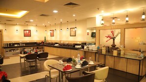 Un restaurante con varias mesas, sillas y una zona de bar.