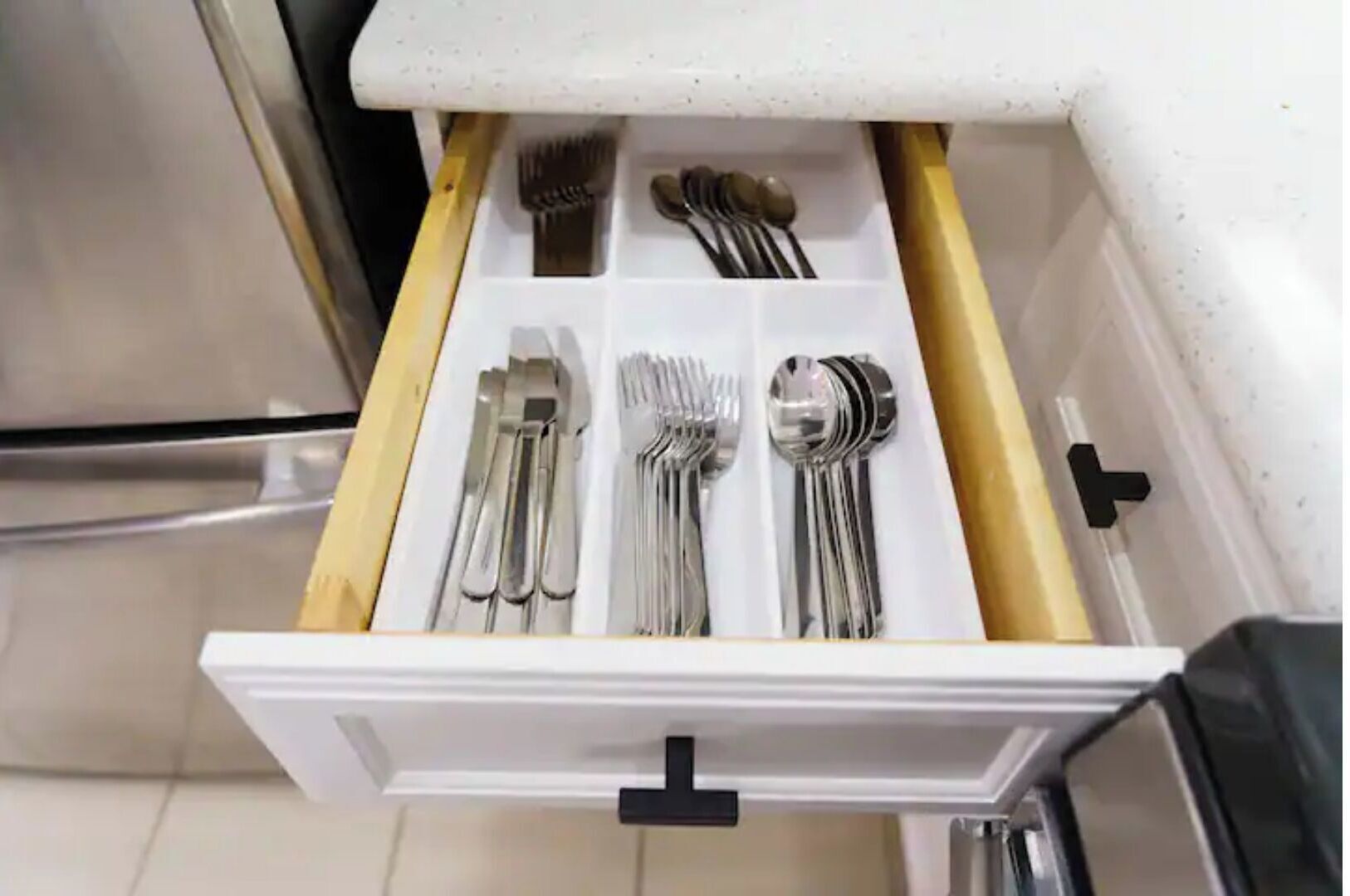 A drawer with utensils neatly organized.