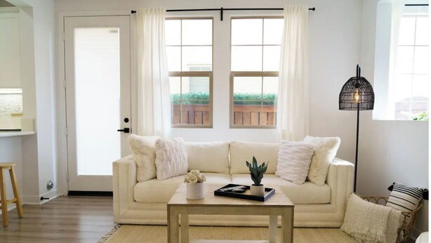 A living room with a beige sofa, a coffee table, and a floor lamp.
