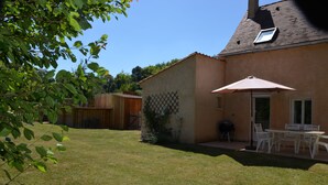 A backyard with a patio area, outdoor furniture, and a wooden fence. - Air-conditioned, garden, private heated pool, pets welcome.  (Eyraud-Crempse-Maurens)