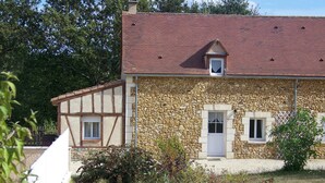 Un bâtiment en pierre avec un toit rouge et une petite fenêtre.