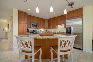 Enjoy cooking in this well-equipped kitchen with a central island, stainless steel appliances, and ample seating for two.